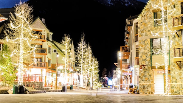 A hotel with a stone facade, multiple balconies, and a mountain backdrop. - S2755-0 (Keystone)