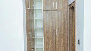 Ein Flur mit einem Holzschrank, einem weißen Regal und einer Tür.