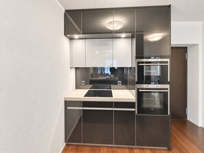 Een moderne keuken met een ingebouwde oven, een kookplaat en een magnetron.