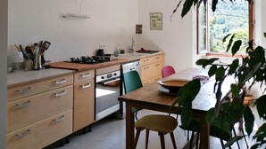 A kitchen with a dining area, featuring a stove, sink, and cabinets. - Charming, quiet house with patio and pool. Surrounding countryside (Sabran)