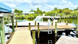 A wooden dock with a boat moored at the end.