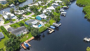 An aerial view of a residential area with houses, docks, and a river.