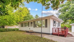 A single-story mobile home with a front porch and a small deck. - Welcoming 2-bedroom home with large deck and central location. (Waterloo)