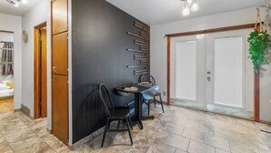 A dining area with a dark wall, wooden cabinets, and a tiled floor. - Welcoming 2-bedroom home with large deck and central location. (Waterloo)