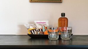 Una mesa con aperitivos, una botella y vasos.