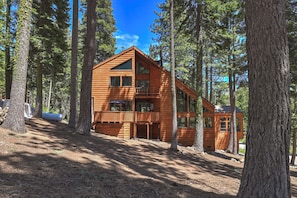 A wooden cabin with a balcony, surrounded by tall trees. - Tahoe Summer Escape • Theater, Gym & Next to Lake! (Tahoe City)