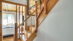 A wooden staircase leading to a bedroom with a bed and curtains. - < 1 Mi to Beaches: Home w/ Deck in Oak Bluffs (Oak Bluffs)