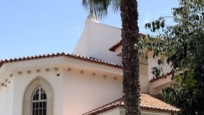 A building with a white facade, a tiled roof, and a palm tree in front. - B Beach Apartment Armaçao de Pêra - Apartamento com vista ao mar (Armação de Pêra)