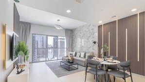A modern living room with a sofa, coffee table, and dining area with chairs.