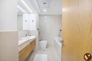 A modern bathroom with a sink, mirror, and toilet.