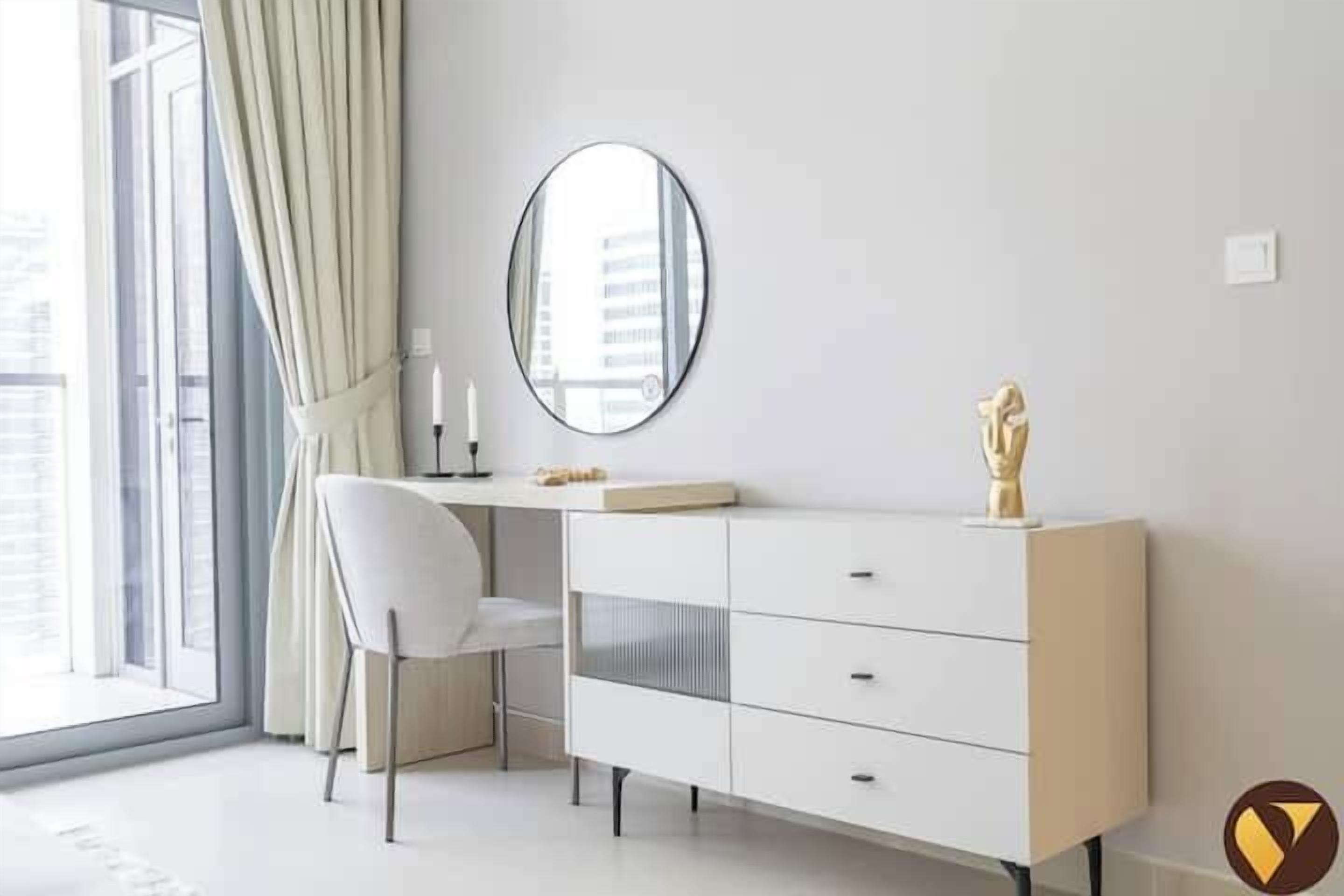A modern bedroom with a white desk, a mirror, and a dresser.