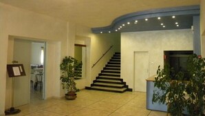 A spacious living area with a staircase, a dining area, and a kitchen visible in the background. - PARK HOTEL (Lido di Camaiore)
