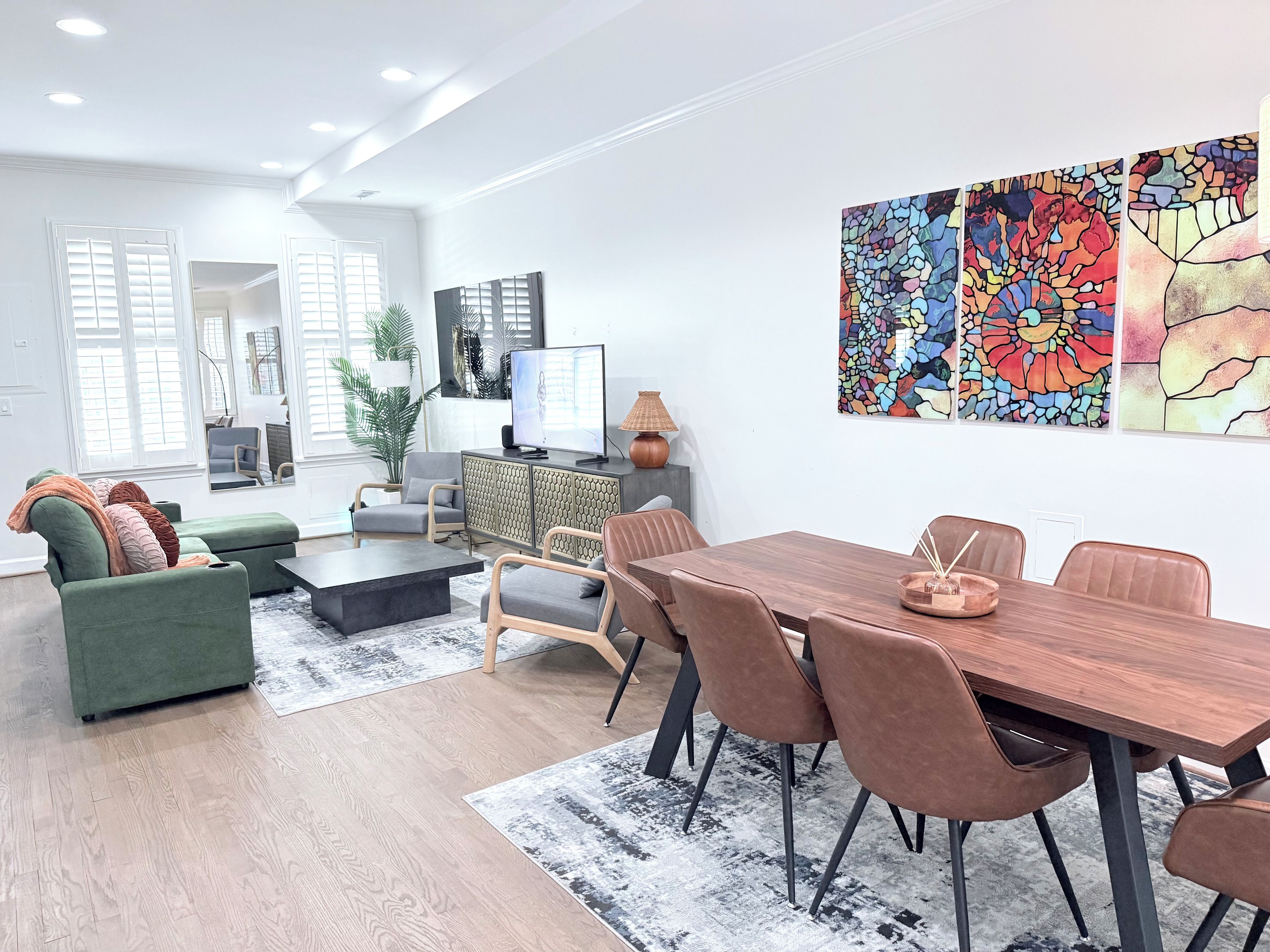 Una sala moderna con comedor, ventanas amplias y obras de arte en la pared.