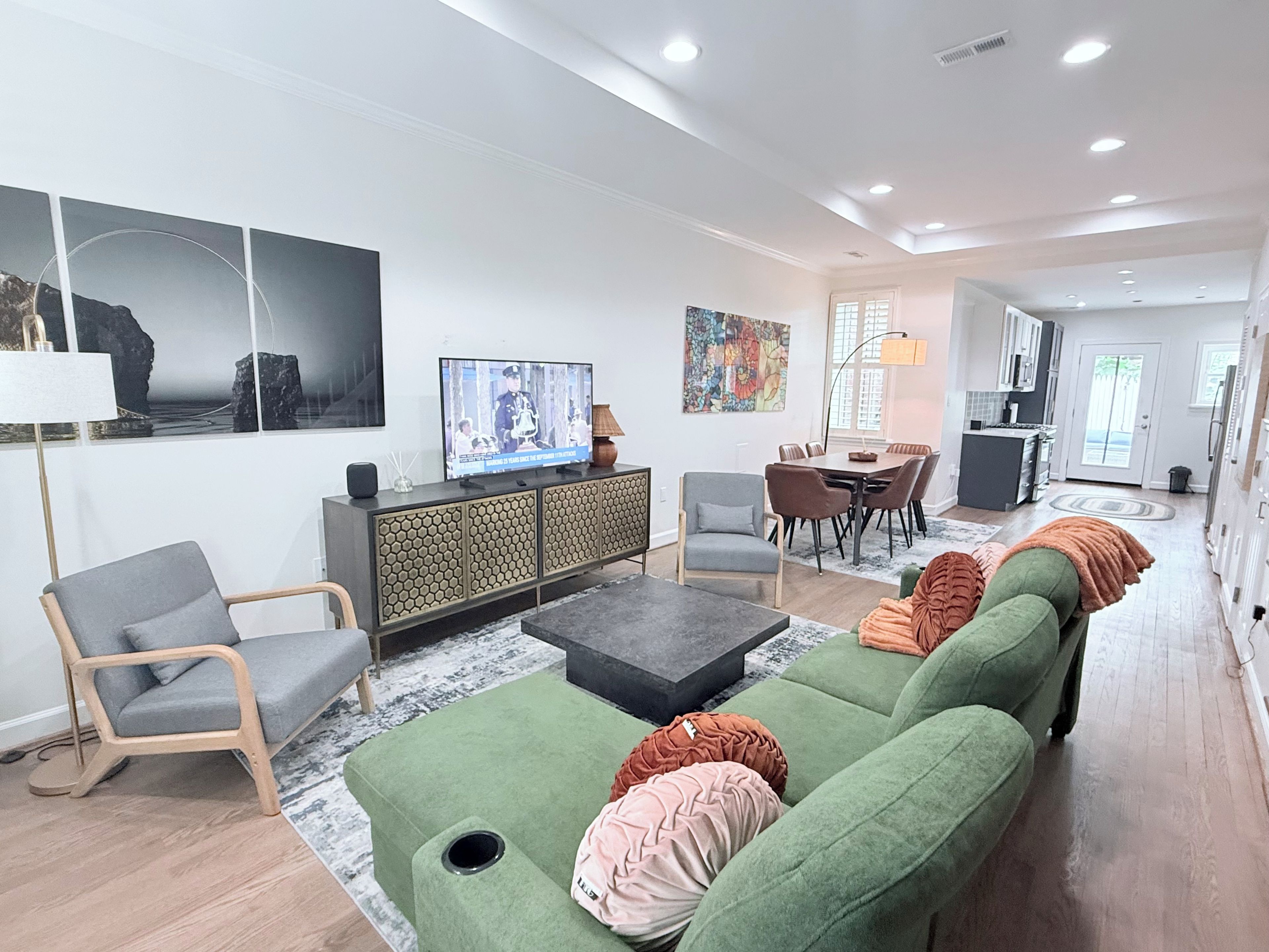 Una sala de estar moderna con un juego de sofá, televisión y comedor.