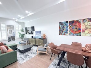 A modern living room with a flat-screen TV, a dining table, and a large window. - Striking 2bed, 2 Bath B&B in  Washington (Washington)