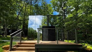 A modern outdoor staircase leading to a platform with a metal railing, surrounded by lush greenery. - Mirror Cabin - Reflections (Balsam Grove)