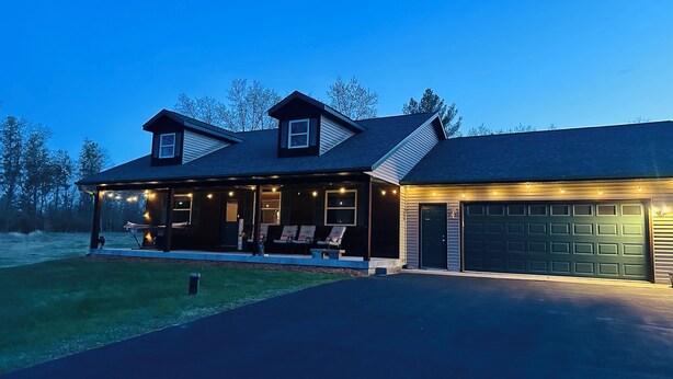 A two-story house with a covered porch, a garage, and a well-maintained lawn. - Rome Ranch Retreat: Golf + Lake + Pool + ATV + Dog + Disc & Foot Golf too! (Nekoosa)