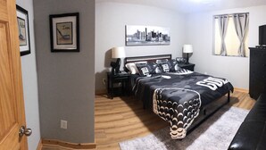 A bedroom with a bed, bedside tables, a lamp, a television, and framed pictures on the wall. - Rome Ranch Retreat: Golf + Lake + Pool + ATV + Dog + Disc & Foot Golf too! (Nekoosa)