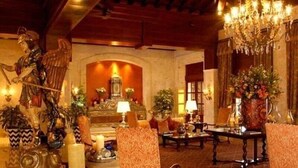 Un lobby espacioso con muebles ornamentados, un candelabro y una estatua.