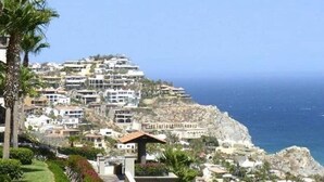 Zona residencial costera con casas construidas en una ladera con vistas al mar.