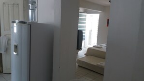 A modern kitchen with a refrigerator, a sink, and a window.