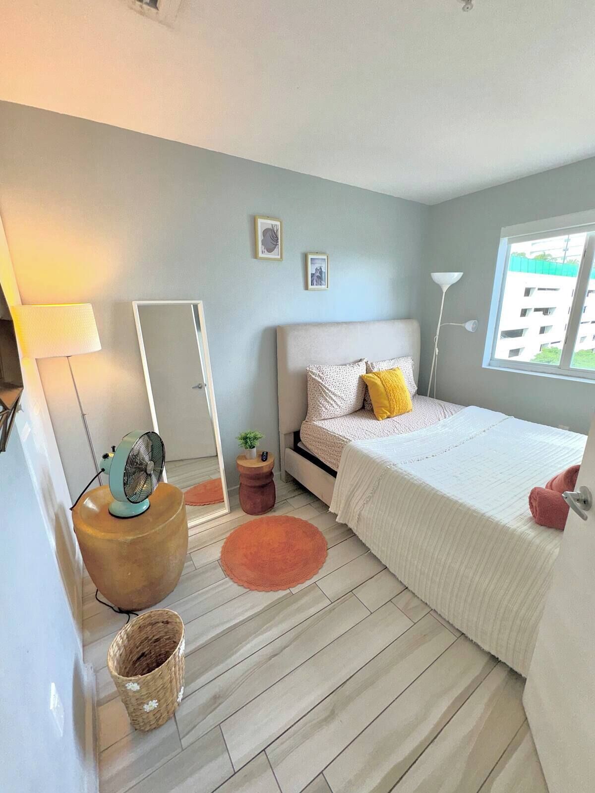 Ein modernes Schlafzimmer mit Bett, Nachttisch, Lampe und Fenster mit Blick.