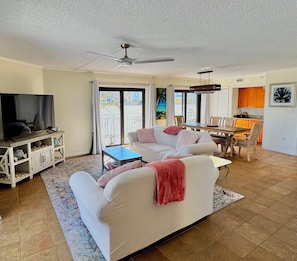 A living room with a sofa, TV, and dining area.
