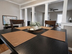 Une salle à manger avec une table en bois foncé, deux chaises et un objet décoratif placé au centre.