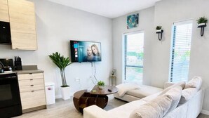 A modern living room with a sofa, a coffee table, and a TV. - Your home away from home (Des Moines)