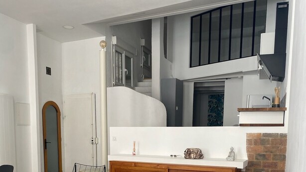 A modern living room with a grey sofa, wooden cabinet, and a small table.