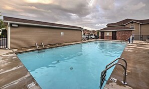 A rectangular swimming pool with metal ladders, a 'NO DIVING' sign, and a brick building in the background. - Bigfoots' Bluff Retreat (Branson)