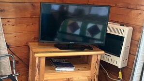 Un televisor sobre un atril de madera con un libro titulado "Homer" debajo.