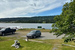 Un estacionamiento junto al lago con un automóvil y un pequeño avión.