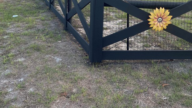 Une entrée fermée par un portail mène au Bunny Hot Resort, et une pancarte représente un palmier et un autobus.