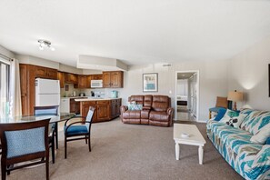 A compact living space with a kitchenette, a dining area, a sofa, and a recliner.