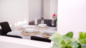 A dining table set with plates, cutlery, and glasses, surrounded by chairs. - Family And Remote Work Friendly-Only 4 Minutes from The Pacific Werribee (Werribee)