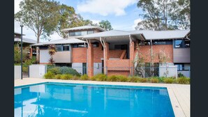 Un edificio residencial moderno con piscina al frente.