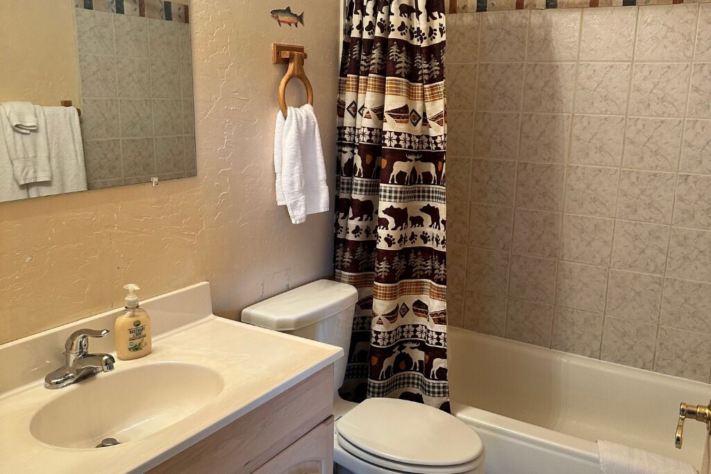 A bathroom with a sink, toilet, and bathtub.