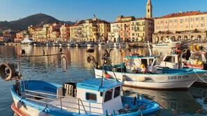 Un port où sont amarrés des bateaux, une tour imposante et, au loin, des bâtiments aux couleurs vives.