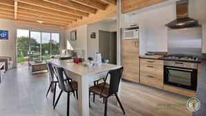 A modern kitchen with a central island, wooden cabinets, and a built-in oven.