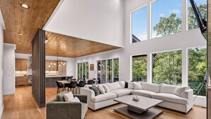 A spacious living area with a large sectional sofa, a coffee table, and a dining area with chairs and a table. - Modern Mountain Haus - 7 bedroom/5 bath/5 decks/4 fireplaces/Theater - 6195 sqft (Blue Ridge)