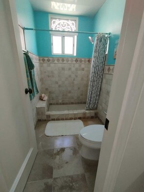 Een douche, handdoeken, zeep, toiletpapier