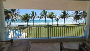 A balcony with a view of the ocean and palm trees. - A-2 Oceanfront at The Victorian (Cabarete)