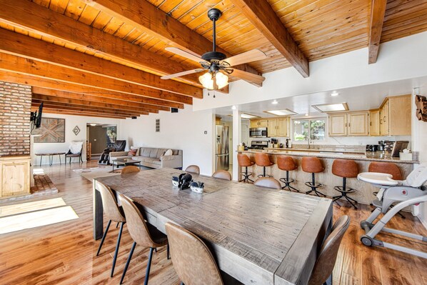 A spacious kitchen with wooden cabinets, a large island, and bar stools.
