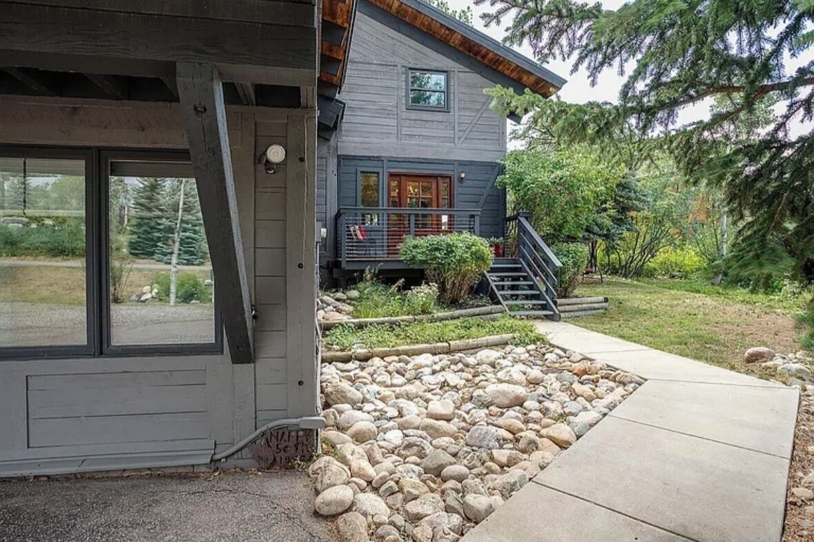 A two-story house with a stone pathway leading to the front door.
