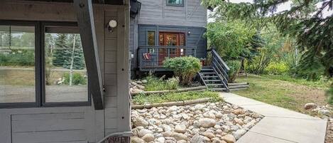 A two-story house with a stone pathway leading to the front door.