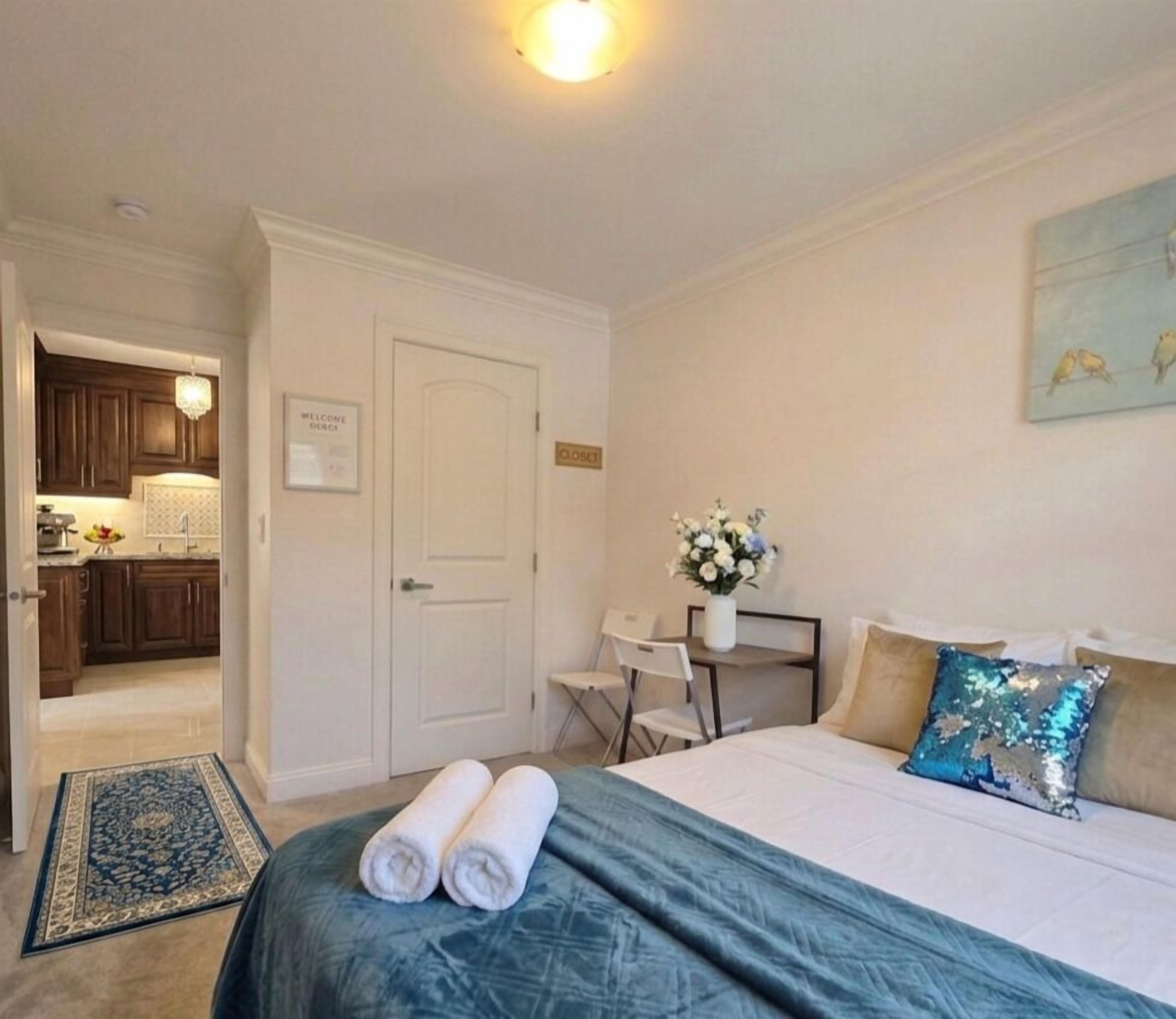 Una habitación de hotel con una cama, un escritorio, una silla, una mesita y una puerta.