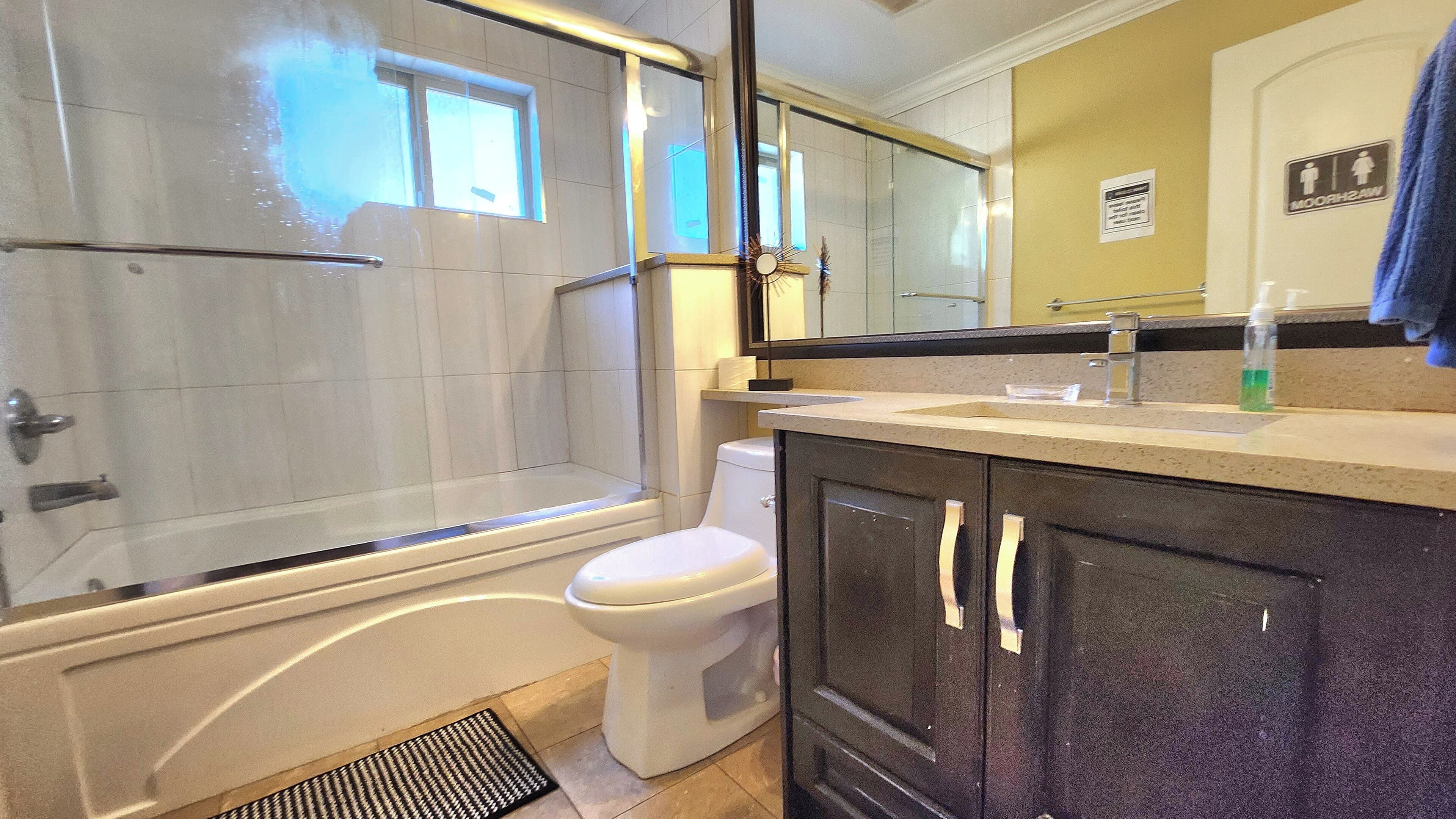 A bathroom with a bathtub, toilet, and a shower area.