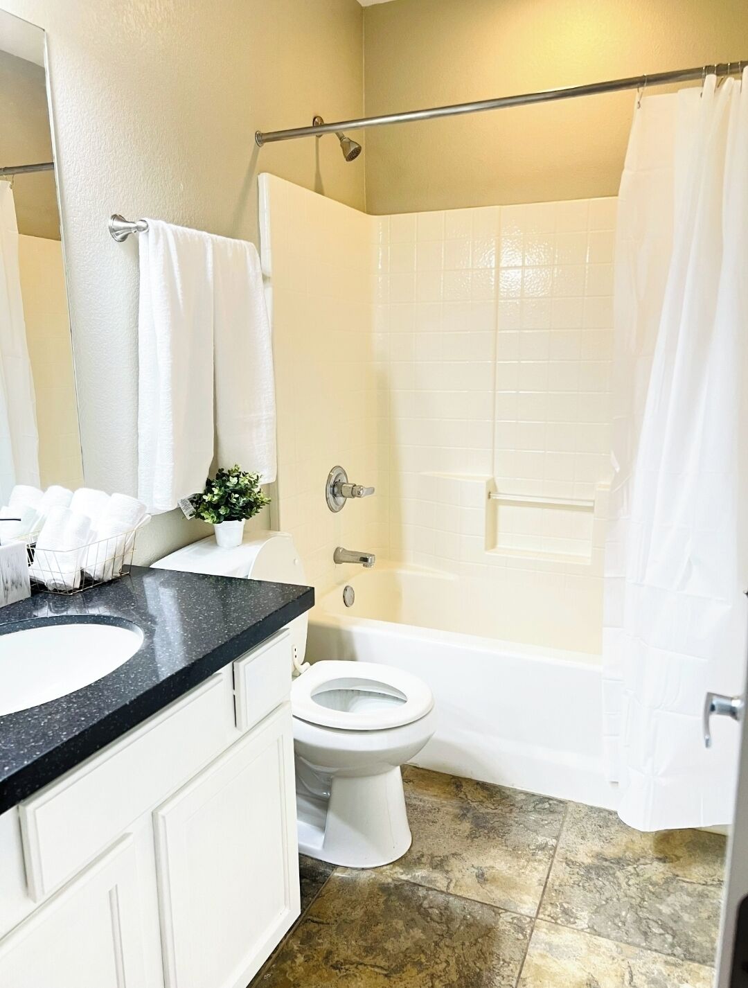 Une salle de bain avec un lavabo, des toilettes et une baignoire, le tout de couleur blanche.