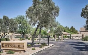 A gated entrance to Ravenswood with a sign, a lamp post, and a clear sky. - Phoenix Valley Stay (PHOENIX)